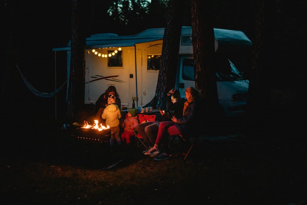 pexels photo 4484242 4484242 1 Family enjoying a warm night by the campfire beside their campervan in Lithuania.