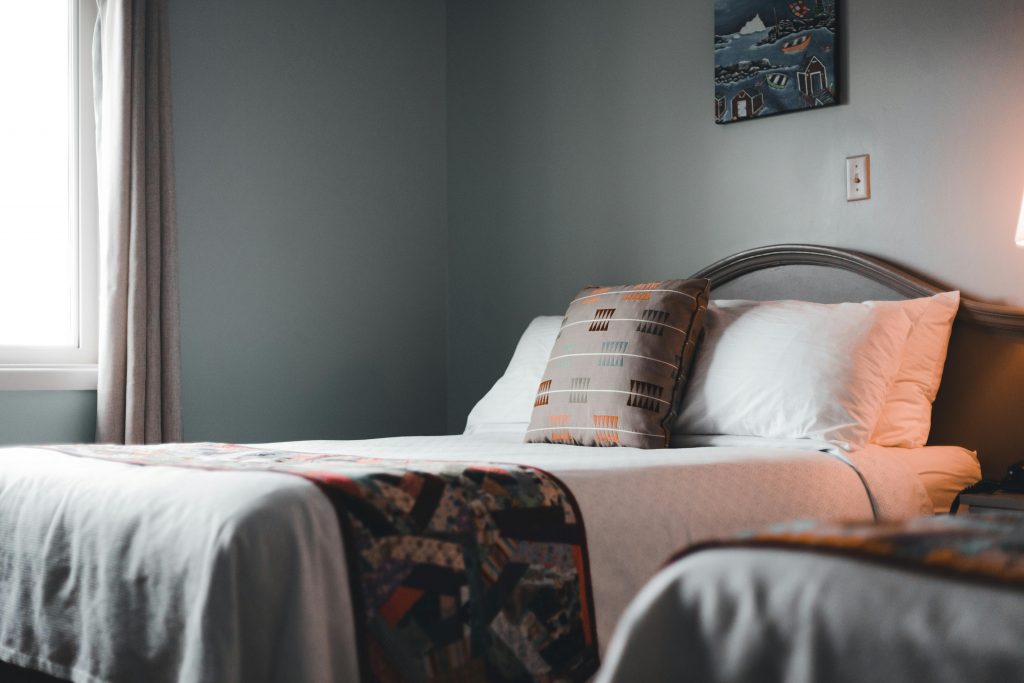 pexels photo 9582660 9582660 Inviting hotel room interior with a neatly arranged bed and soft lighting.